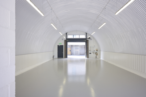 The front of an arch with an open electric roller shutter entrance big enough for vehicle access, and separate pedestrian door.