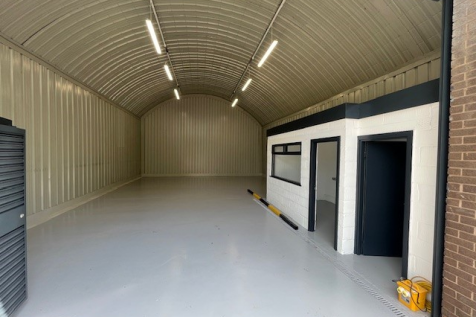 An empty arch with white lining and a WC cubicle to the front.