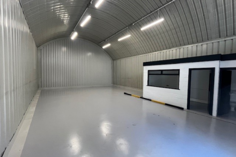 An empty arch with white lining and a WC cubicle to the front.