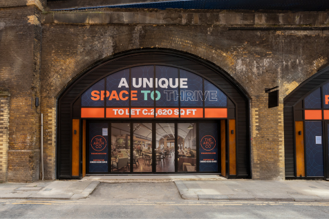 The front of an arch, with a fully glazed frontage and door allowing you to see into the arch interior.