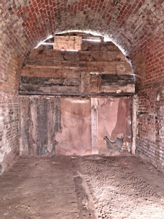 An empty arch with white lining and glazing at the front, on  the lower level only.