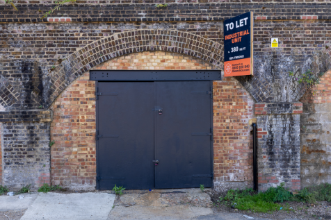 The front of an arch with a closed metal concertina door that can be pulled back fully.
