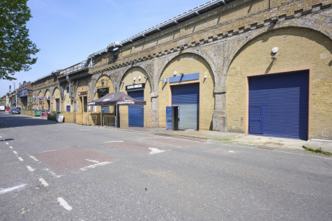 An estate, with multiple arches next to each other. The arches have closed electric roller shutter entrances.