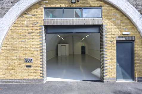 The front of an arch with an open electric roller shutter entrance big enough for vehicle access, and separate pedestrian door.