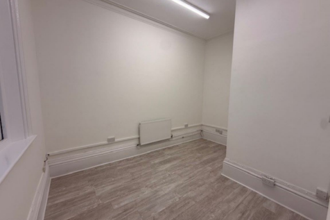 The front of an arch with an open electric roller shutter entrance big enough for vehicle access, and separate pedestrian door.