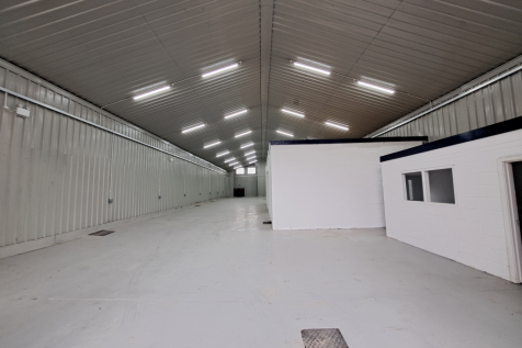 An empty arch with white lining and a WC cubicle to the front.