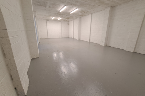 An empty arch with white lining and a WC cubicle to the front.