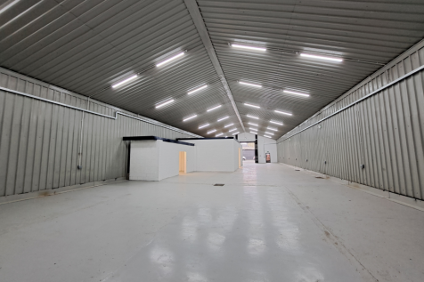 An empty arch with white lining and a WC cubicle to the front.