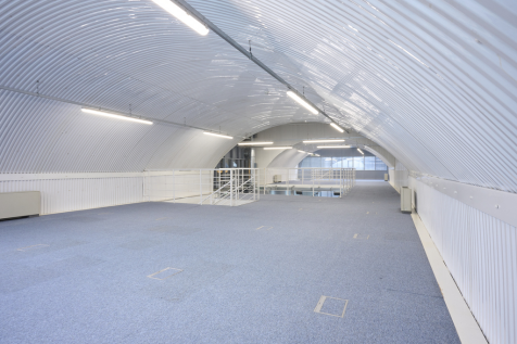 The mezzanine level of an arch, with carpet and lined white.