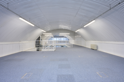 The mezzanine level of an arch, with carpet and lined white.