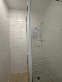 An empty arch with white lining and a WC cubicle to the back.