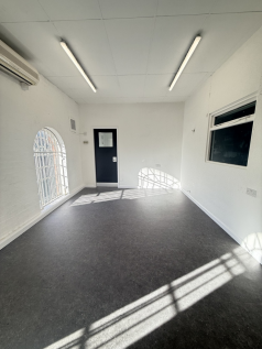 The ground floor of an empty arch, suitable to use as an office unit, with carpet and a WC.