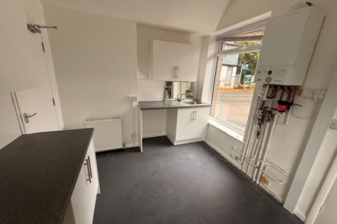 An empty arch with white lining and a WC cubicle to the front.