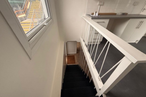 An estate, with multiple arches next to each other. The arches have closed electric roller shutter entrances.
