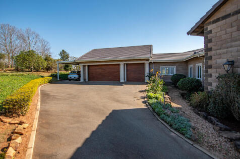 Driveway leading up to triple garage and carport