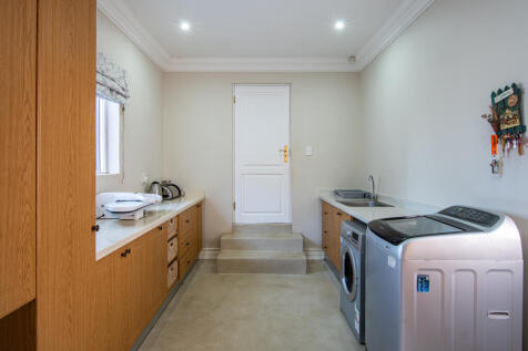 Separate laundry leading into triple garage