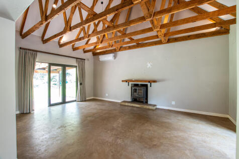 Lounge with magnificent wood beams leading out to large undercover verandah