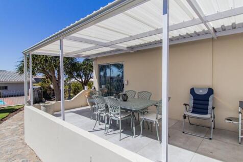 Sheltered patio overlooking the sparkling pool