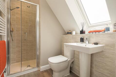 En suite shower with sloped ceiling and large window