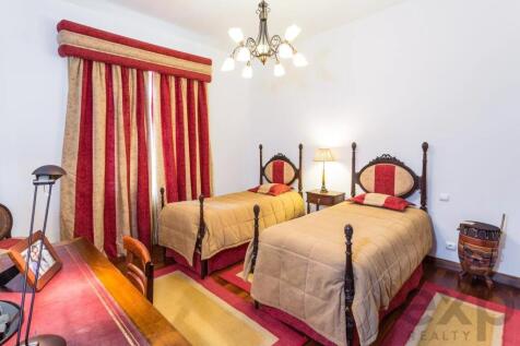 A cozy bedroom with two twin beds, elegant red and