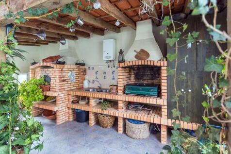 Outdoor brick kitchen with a traditional grill, su