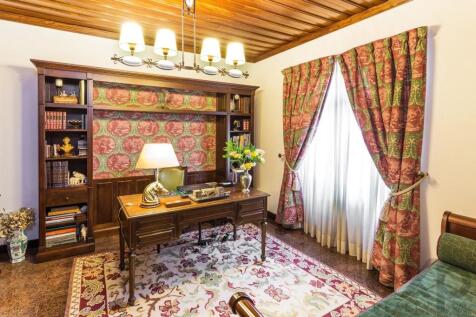 Cozy study room with a wooden desk, bookshelves, f