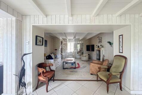 A cozy living room with white wooden walls and cei