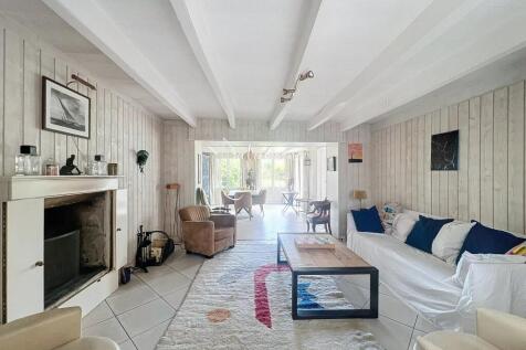 A cozy living room with light wood walls, a firepl