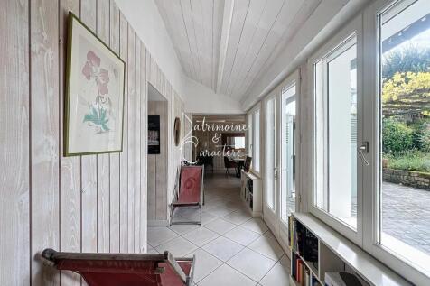 A bright hallway with light wood paneling, large w