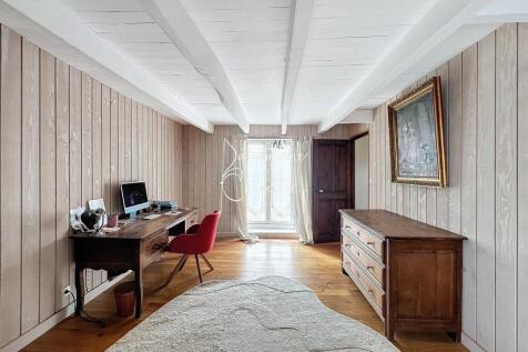 A cozy room with wooden paneling, featuring a desk
