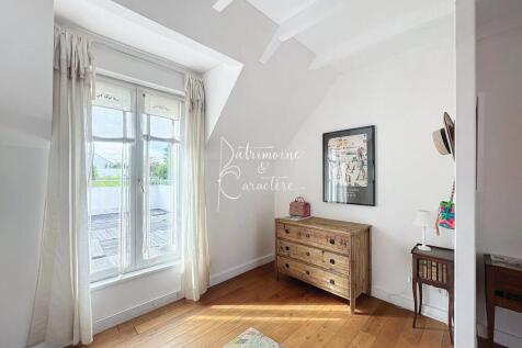 A bright room with a large window, wooden floors, 