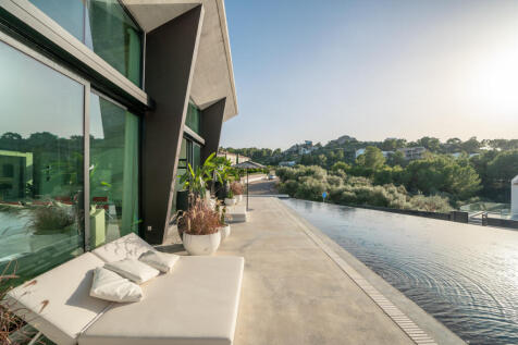 Outdoor loungers by the pool with a view of the greenery