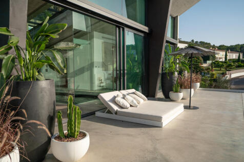 Outdoor sunbathing area by the pool with plants
