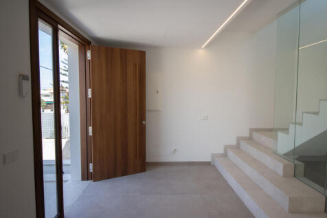 Entrance area with staircase upstairs and passageway between living/dining/kitchen area