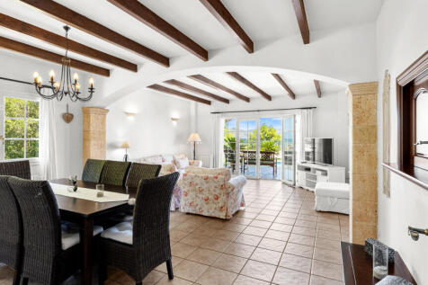 Ess- und Wohnbereich mit Holzbalken und Fensterfront zum Meer