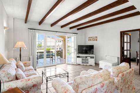 Wohnbereich mit Holzbalken und Fensterfront zum Meer