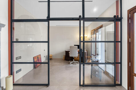 roßzügiges Arbeitszimmer mit modernen Glastüren