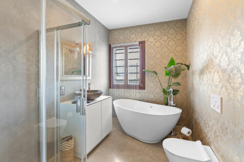 Elegantes Gäste-Badezimmer mit freistehender Wanne und edler Wandgestaltung