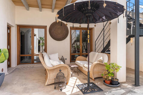 Überdachte Terrasse mit gemütlicher Sitzecke und Blick in den Patio