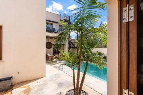 Lichtdurchfluteter Patio mit Palmen und Poolblick