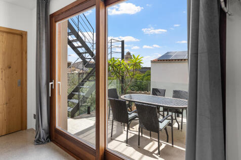 Sonnige Terrasse mit Esstisch und Blick in den Patio