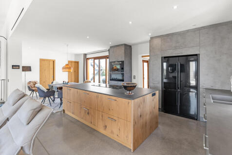 Moderne Küche mit Kochinsel und schwarzem Kühlschrank als Akzent