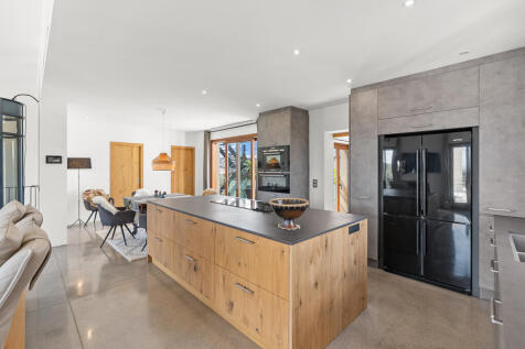 Moderne Designküche mit großer Kochinsel und hochwertigen Geräten