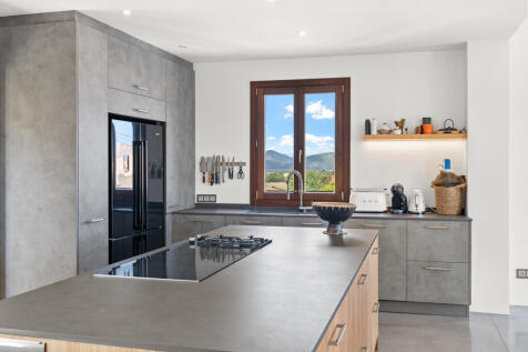 ffene Küche mit Kochinsel und Bergblick aus dem Fenster