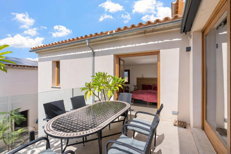 Terrasse mit Esstisch und mediterraner Bepflanzung