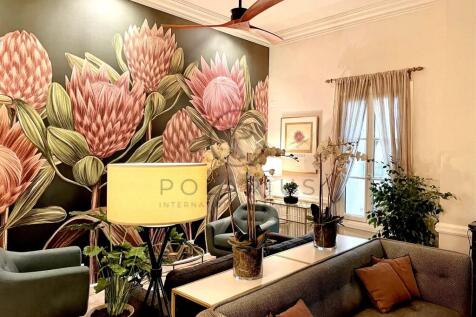 A cozy living room features a large floral mural w