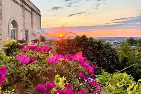 A scenic sunset view from a balcony with vibrant p