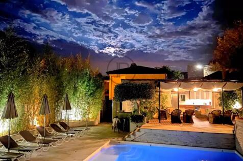 A serene outdoor scene at night features a well-li