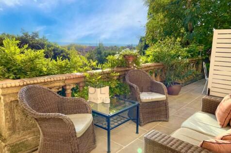 A serene patio setting with wicker chairs and a sm