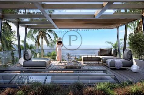 A woman in a hat stands on a modern patio overlook